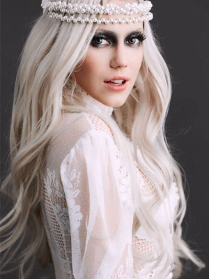 A woman wearing a luxury blonde wig with pearl headpiece